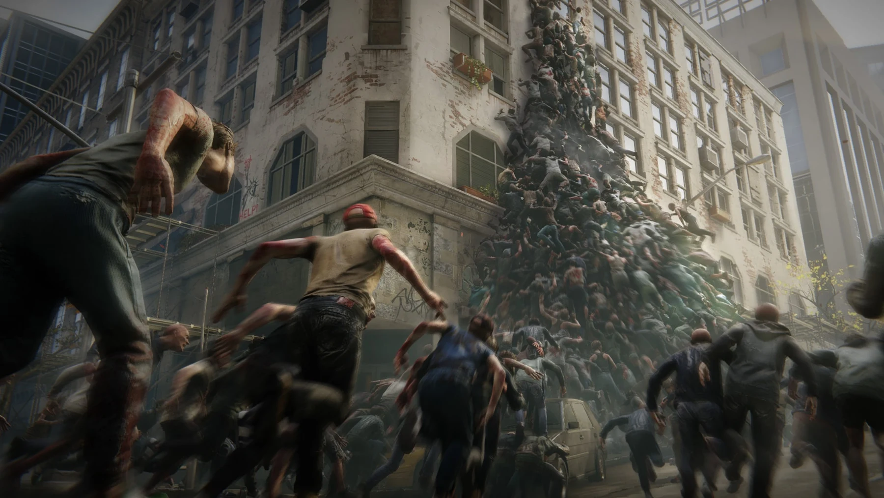 A vast horde of zombies piles up an apartment building while more infected charge through the street in World War Z.